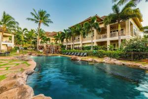 a pool in front of a resort with palm trees at D211 Second Floor 3-bedroom Poolside Lanai in Koloa