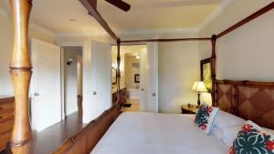 a bedroom with a large bed with a wooden frame at F211 Second Floor 3-bedroom Poolside Lanai in Koloa