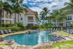 a pool at a resort with chairs and palm trees at F211 Second Floor 3-bedroom Poolside Lanai in Koloa