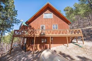 uma grande casa de madeira com um deque envolvente em Holiday House em Rapid City