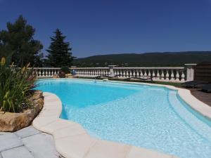 a large blue swimming pool in a yard at Appartement Vue Montagne in Garéoult