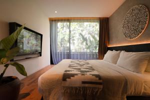 a bedroom with a large bed and a window at Titik Dua Ubud in Ubud