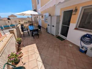 un patio con mesa, sillas y sombrilla en Viña Home, en Torre del Mar