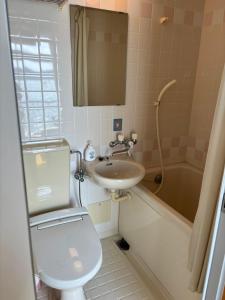 a bathroom with a toilet and a sink and a tub at Irifune in Tonosho