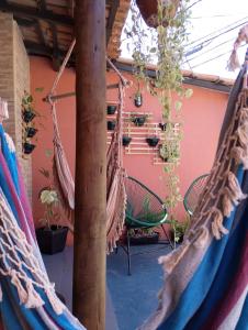 a couple of hammocks in a patio with plants at Tiwá Hostel - antigo DaSanta - CENTRO in Arraial d'Ajuda