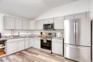 a kitchen with white cabinets and stainless steel appliances at Quaint New Orleans Duplex 3 Mi to French Quarter in New Orleans
