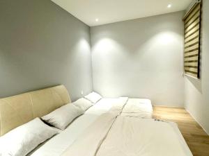 una camera da letto con un grande letto bianco di Armadale Residence 3R3B@GalaCity a Kuching