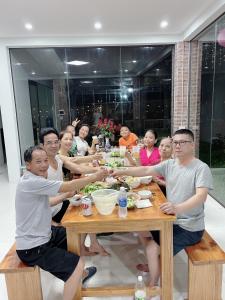 un grupo de personas sentadas en una mesa comiendo comida en Kazin Homestay Ba vì, en Ba Vì