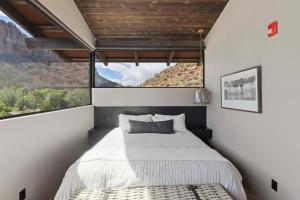 ein Schlafzimmer mit einem Bett und einem großen Fenster in der Unterkunft Zion loft with canyon views - unit 3 in Springdale