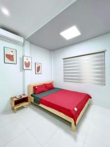 1 dormitorio con cama roja y mesa en Kazin Homestay Ba vì, en Ba Vì