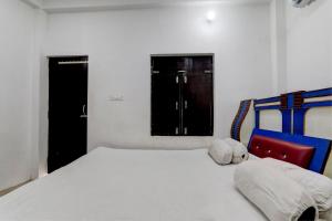 a white bedroom with a bed and a window at OYO The Hotal Vishnu in Bettiah