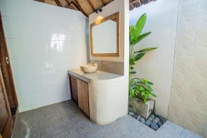 a bathroom with a sink and a mirror at The Parnas in Nusa Lembongan