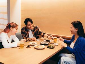 京都的住宿－MIMARU KYOTO NIJO CASTLE ，一群坐在餐桌旁吃食物的三个女人