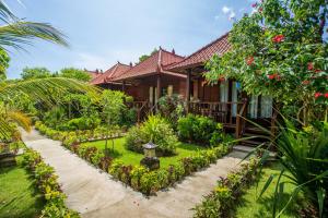 una casa con un jardín delante de ella en The Parnas, en Nusa Lembongan