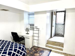 um quarto com uma cama, uma secretária e uma cadeira em Manhattan in 2 stopages, 2 Bedrooms Apt with private Backyard in LIC !!! em Long Island City