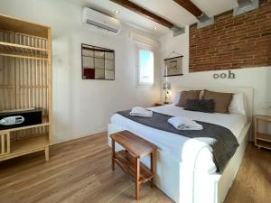 um quarto com uma grande cama branca e uma televisão em Stay U-nique Apartments Torrent em Barcelona