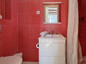 uma casa de banho em azulejos vermelhos com um lavatório e um espelho em Stay U-nique Apartments Torrent em Barcelona
