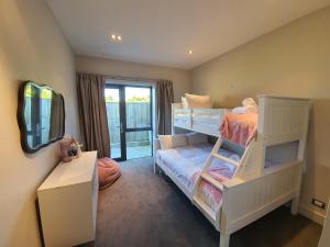 a bedroom with two bunk beds and a mirror at Private Retreat - Stunning Lake & Mountain Views in Queenstown