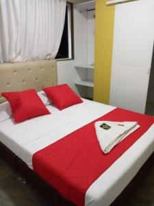 a bedroom with a bed with red pillows at Hotel Oiba Alfa Plaza in Oiba