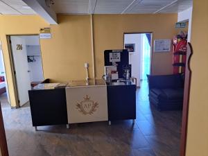 a reception desk in a room with a blue couch at Hotel Oiba Alfa Plaza in Oiba