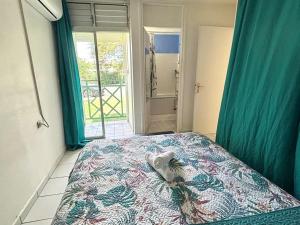 een slaapkamer met een bed met een handdoek erop bij Le refuge de Chrystel : Plage accessible à pied in Le Gosier +6 foto's