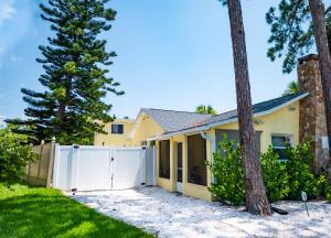 a house with a white fence at Mid-Century 1bd House - Beach Gear - 5min Walk to Beach in Clearwater Beach
