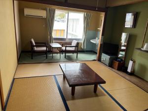 a living room with a coffee table and a dining room at Irifune in Tonosho