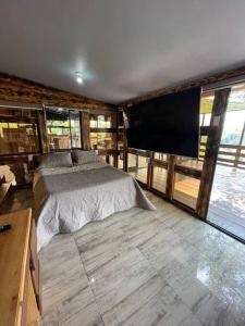 - une chambre avec un lit et une télévision à écran plat dans l'établissement Cabaña entre montañas + Jacuzzi, à Quindío