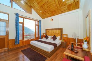 a bedroom with a bed in a room with wooden ceilings at Orchard Heaven in Manāli