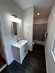 een witte badkamer met een wastafel en een douche bij 7 Bedroom House! Walk to Niagara Falls! New Whole House in Niagara Falls
