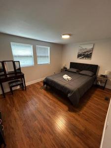 een slaapkamer met een bed en een houten vloer bij 7 Bedroom House! Walk to Niagara Falls! New Whole House in Niagara Falls