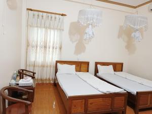 a bedroom with two beds and a chandelier at Minh Loan Hotel in Nước Hai