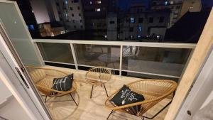 - un balcon avec 3 chaises et des oreillers dans l'établissement Hermoso mono ambiente en zona centro caba, à Buenos Aires