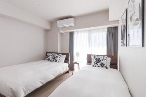 una camera da letto con due letti e una finestra di LANG Hotel Kameido-2#Near Akihabara#チェックアウトのみ清掃あり a Tokyo