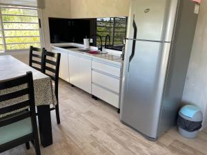 a kitchen with a stainless steel refrigerator and a table at Las Pirquitas Villa Giardino in Huerta Grande