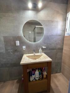 une salle de bain avec un lavabo et un miroir dans l'établissement Las Pirquitas Villa Giardino, à Huerta Grande 31 autres photos
