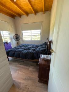 une chambre avec un lit, une table et une fenêtre dans l'établissement Las Pirquitas Villa Giardino, à Huerta Grande