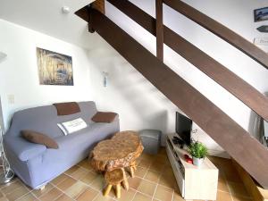 uma sala de estar com um sofá e uma mesa em Maison Sarzeau, 2 pièces, 3 personnes - FR-1-639-113 em Sarzeau