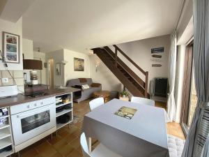 uma cozinha e sala de estar com uma mesa e um sofá em Maison Sarzeau, 2 pièces, 3 personnes - FR-1-639-113 em Sarzeau