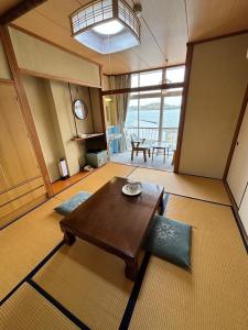 a living room with a wooden table and a large window at Irifune in Tonosho