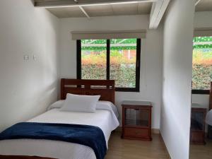 1 dormitorio con cama y ventana en Finca Hotel 12 Palmas- Aeropuerto JMC, en Rionegro