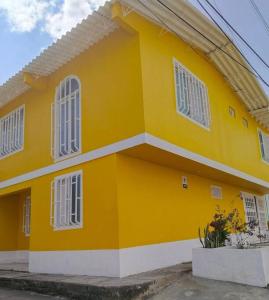 une maison jaune avec des fenêtres blanches sur une rue dans l'établissement Encantadora Casa, Calima Darién, à Darién