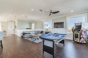 uma sala de estar com uma mesa de bilhar e uma televisão em Playa Esmeralda Vacation Home Up To 14 People em Bradenton Beach