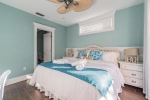a bedroom with a bed with blue walls and a fan at Playa Esmeralda Home! Bradenton Beach Now Open!!! in Bradenton Beach +59 photos