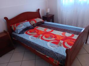 a bed with a quilt and pillows on it at Pagerie bas de villa in Les Trois-Îlets