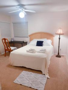 1 dormitorio con 1 cama blanca grande y ventilador en Quiet comfortable whole house en Riverside