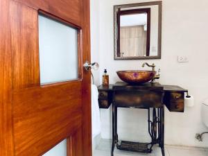 baño con lavabo y puerta de madera en ¡Fogata y Lujo! en Ambato