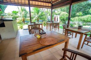 a wooden table and chairs on a patio at The Parnas in Nusa Lembongan