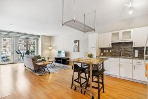 an open kitchen and living room with a table and chairs at CozySuites Mill District with pool, gym #01 in Minneapolis