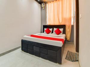 een slaapkamer met een bed met rode kussens bij Super OYO Flagship Hotel Iris Lite in New Delhi